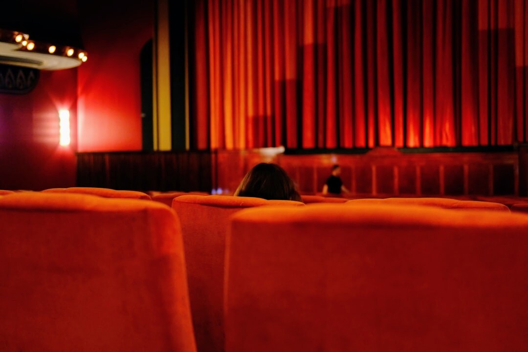 Elegant theatre entrance with warm lighting and red velvet curtains